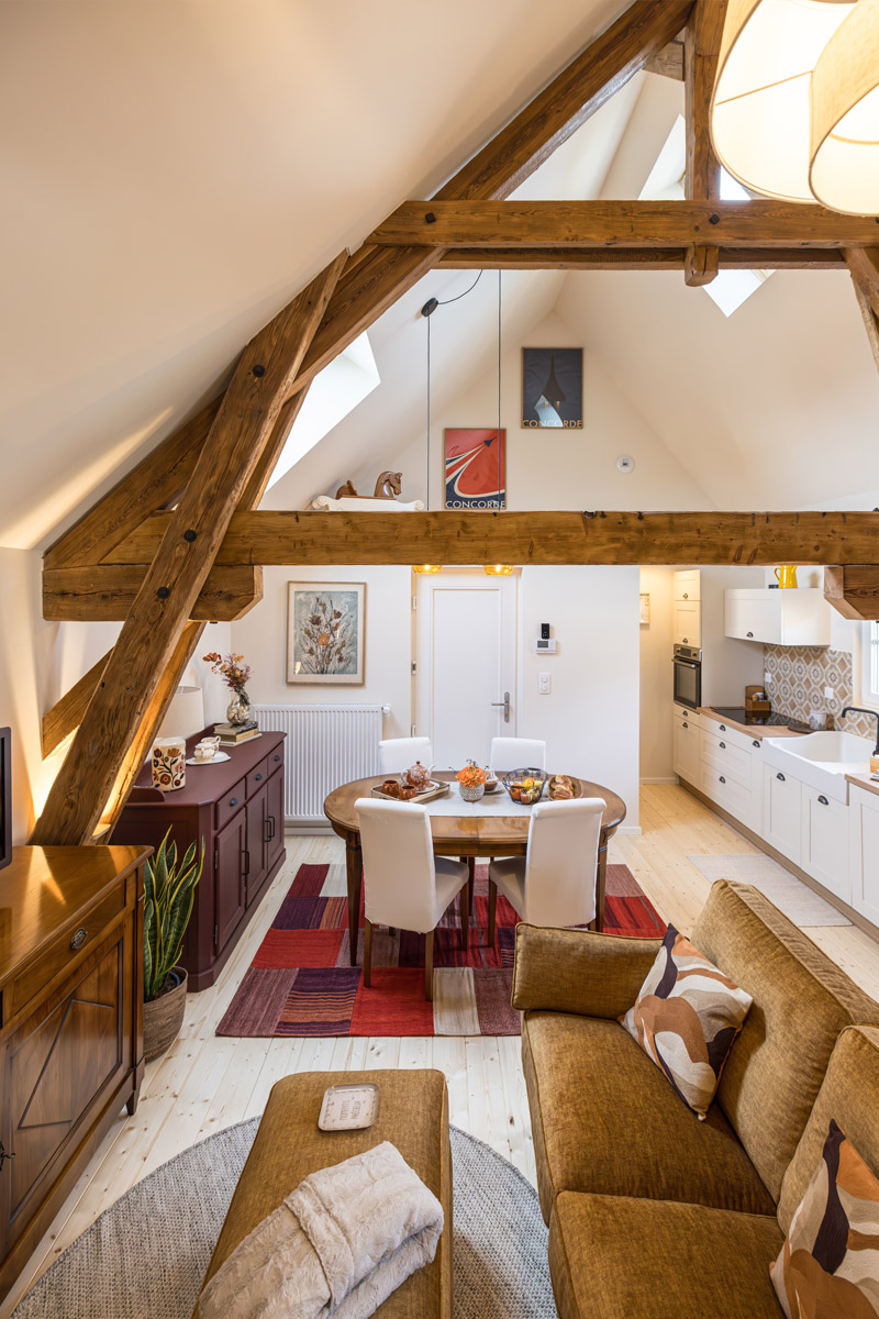 Photo en vue plongeante de l'espace salon, l'espace repas et la cuisine tout équipée du gîte « À toi l'Aviateur ! » à Wattwiller - photo Marie Soehnlen